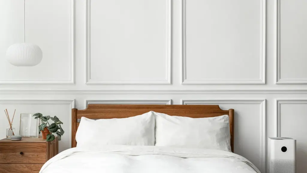 Cama arrumada com cabeceira de madeira em um quarto